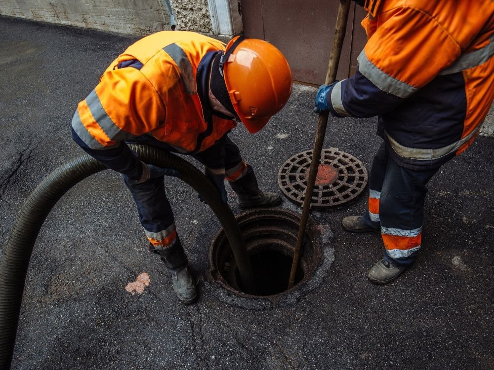 Equipe especializada trabalhando em bueiro urbano, mostrando na prática como desentupir a rede de esgoto de forma eficiente.